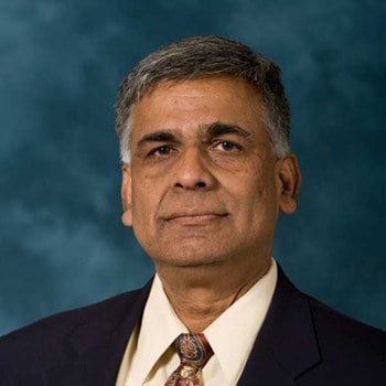 Vijay Nair smiles and poses for a portrait.