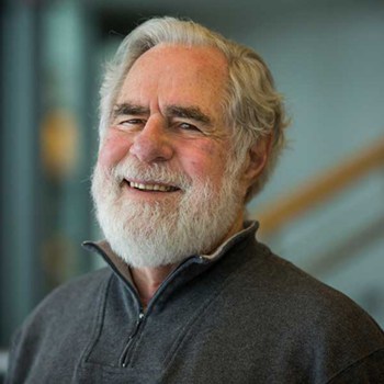 Stephen M. Pollock smiles and poses for a portrait.