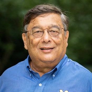 Prakash Sathe smiles and poses for a portrait.