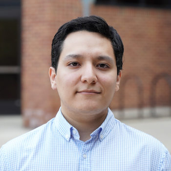 Juan Estrada smiles and poses for a portrait.