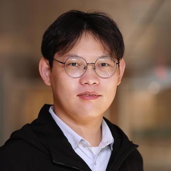 Bo Zhou smiles and poses for a portrait.