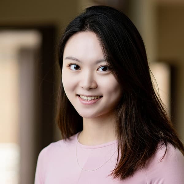 Yili Wang smiles and poses for a portrait.