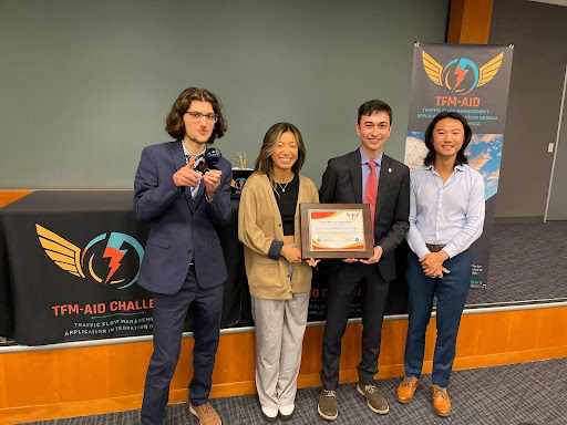 Four students hold a trophy from the federal aviation association