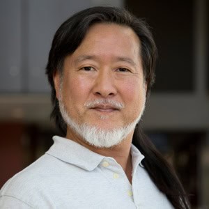 Gene Kim smiles and poses for a portrait.