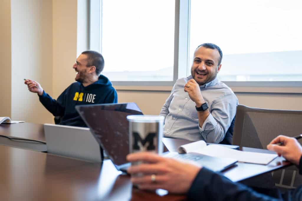 U-M IOE assistant professor Albert Berahas and associate professor Raed Al Kontar laugh during a meeting with U-M women’s soccer coaches.